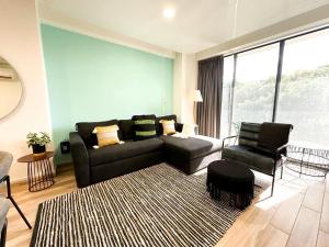 un salon avec un canapé et une chaise dans l'établissement Zuhause Apartments 5th AV, à Playa del Carmen 59 autres photos