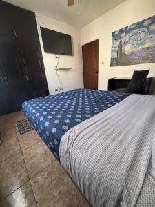 een slaapkamer met een bed en een tv aan de muur bij Habitacion Arboleda in Saltillo