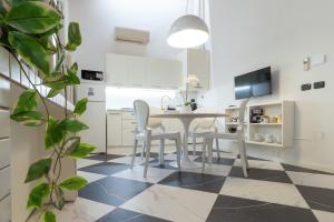 a kitchen and dining room with a table and chairs at TEATRUM LOFT Teatro Galli -Jacuzzi in camera in Rimini +23 photos