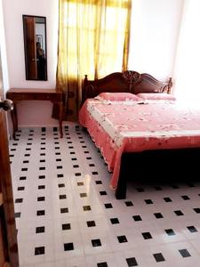 een slaapkamer met een bed en een zwart-witte vloer bij Araz Homestsay in Kota Bharu