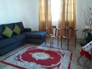 een woonkamer met een bank en twee stoelen bij Araz Homestsay in Kota Bharu