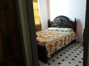 een slaapkamer met een bed met een dekbed erop bij Araz Homestsay in Kota Bharu