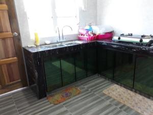 een keuken met een spoelbak en een aanrechtblad bij Araz Homestsay in Kota Bharu