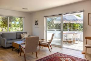a living room with a couch and a table at Bay Haven - Walk to Palm Beach in Waiheke Island