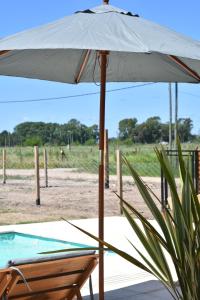 an umbrella and a chair next to a pool at Quinta Natural Glam in San Vicente