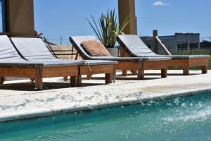 two lounge chairs sitting next to a swimming pool at Quinta Natural Glam in San Vicente