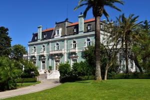里斯本Pestana Palace Lisboa Hotel & National Monument - The Leading Hotels of the World的一座大房子,前面有棕榈树
