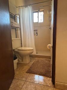 a bathroom with a toilet and a shower with a window at Habitación Roble, cómoda y espaciosa in Saltillo