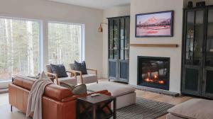 プティット・リヴィエール・サン・フランソワにあるChalet La Rocheuse et SPAのソファと暖炉のあるリビングルーム