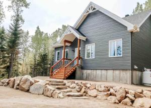 プティット・リヴィエール・サン・フランソワにあるChalet La Rocheuse et SPAの大きな岩の山がある灰色の家