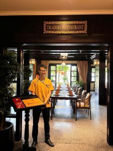a man standing at a table in a restaurant at Little Riverside Hoi An . A Luxury Hotel & Spa in Hoi An