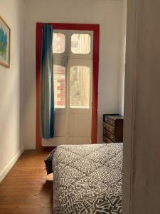 a bedroom with a bed and a window at La Mancha Art Hostel in Valparaíso