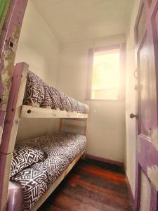 a small room with a bunk bed and a window at La Mancha Art Hostel in Valparaíso