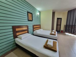 Dos camas en una habitación con paredes verdes. en BCIC Lodge, en Kuantan 14 fotos más