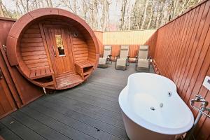 a bathroom with a tub and a toilet in a building at LEVATA Nasu バレルサウナ付きログハウス BBQ可 1棟貸切 6名様まで同料金 in Nasu