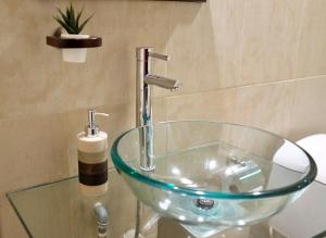 a glass sink with a faucet in a bathroom at Luxury Triplex Penthouse with Balcony and Stunning Mountain Views in Bogotá +132 photos