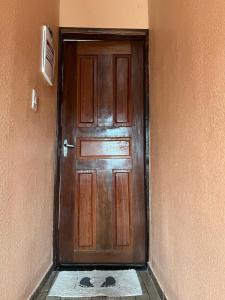 eine Holztür im Flur mit Fliesenboden in der Unterkunft Furnished Apartment Type House for COP30 in Belém