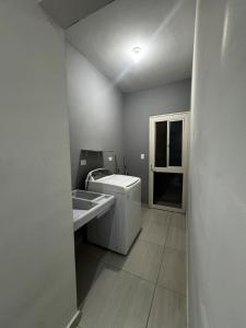 um banheiro com máquina de lavar e pia em The CaSa em Saltillo mais 8 fotografias