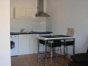 a kitchen with a table and stools and a sink at F2 Le Lavezzi in Ajaccio