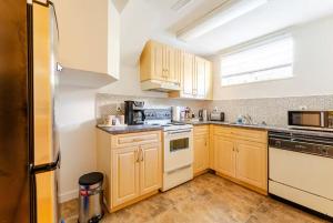 a kitchen with wooden cabinets and white appliances at Spacious & Cozy 1 Bedroom Suite in North Vancouver in North Vancouver