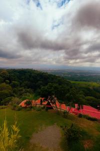 a view of a house on top of a hill at Hotel Mirador Mayday Mountain View in Alajuela City