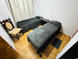 - une chambre avec 2 lits verts et une chaise dans l'établissement Amplio Departamento, à Cañada de Gómez