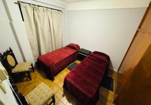 une chambre avec deux lits et une chaise et une fenêtre dans l'établissement Amplio Departamento, à Cañada de Gómez