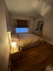 a small bedroom with a bed and a mirror at Modern Flat with Wembley Stadium View in London