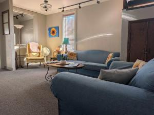 a living room with a blue couch and a table at Group Basecamp 6 Bedrooms Downtown GJ in Grand Junction