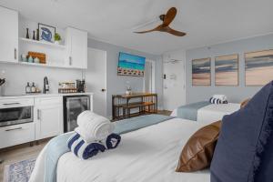 Un dormitorio con dos camas con toallas encima. en Modern Beach Oasis - Sleeps 4 - Pool - Gym - Games, en Daytona Beach 20 fotos más