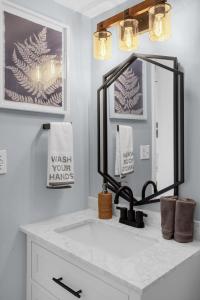 un baño con lavabo y espejo en Modern Beach Oasis - Sleeps 4 - Pool - Gym - Games, en Daytona Beach