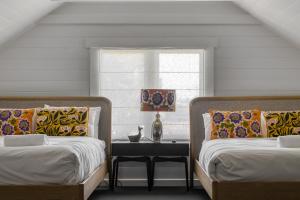 two beds in a room with a table between them at Talina - History in the Heart of St Helens in St Helens