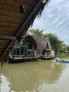a house on a body of water with water at บ้านนกฮูก อิงธารา in Ban Khlong Sai