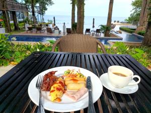 a plate of food and a cup of coffee on a table at Chang Buri Resort & Koh Chang Hillside in Ko Chang