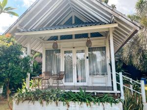 un chalet avec des chaises et une table sur une véranda dans l'établissement Bingin Sun & Moon Villas, à Bingin Beach