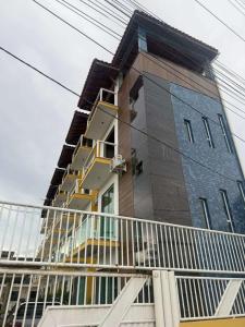 Un edificio alto con un balcón en el frente. en pousada tudo a ver, en Salinas da Margarida