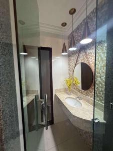 un baño con lavabo y espejo en pousada tudo a ver, en Salinas da Margarida 8 fotos más