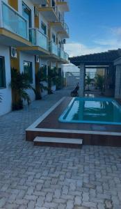 una casa con piscina delante de un edificio en pousada tudo a ver, en Salinas da Margarida