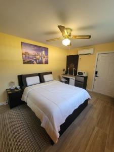 een slaapkamer met een groot bed met een plafondventilator bij Twin Pines Studios in Jacksonville