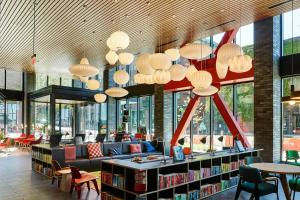 a library with a lot of windows and tables and chairs at citizenM Seattle Pioneer Square in Seattle