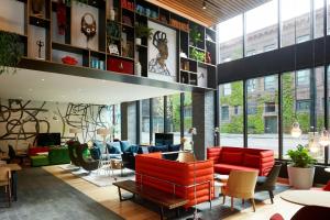 a lobby with red chairs and tables in a building at citizenM Seattle Pioneer Square in Seattle +22 photos