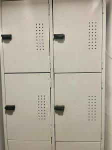 a group of four white lockers in a room at Toca da Mona Roots Hostel in Vitória