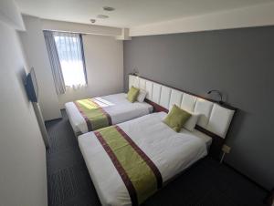 a hotel room with two beds and a window at Asia Hotel Narita in Narita