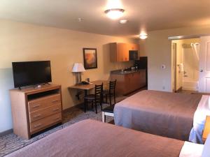 a hotel room with two beds and a flat screen tv at Aviator Suites Hotel Juneau Airport by Aspen Hotels in Juneau