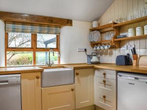 a kitchen with a sink and a dishwasher at Lower Axford Cottage in Callington