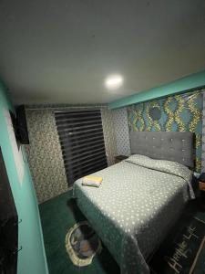 a small bedroom with a bed and a window at Hotel del valle san Miguel 530 in Melipilla