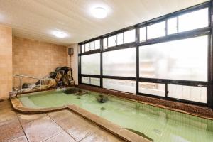 una piscina cubierta en una habitación con ventanas en 割烹旅館 廣美亭, en Hanamaki