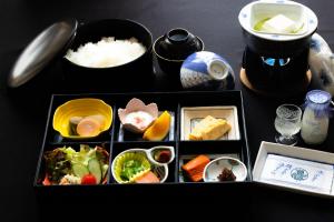 una mesa cubierta con diferentes tipos de alimentos en cajas en 割烹旅館 廣美亭, en Hanamaki