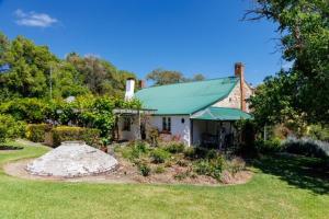 a house with a green roof in a yard at The Olives Heritage House in Yankalilla