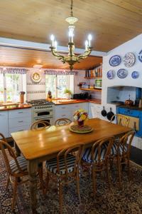 a kitchen with a wooden table with chairs and a chandelier at The Olives Heritage House in Yankalilla